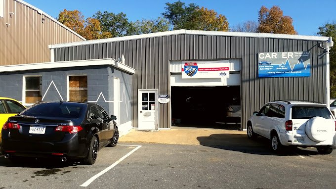 Car repair shop with a black can and a white car waiting for repairs.