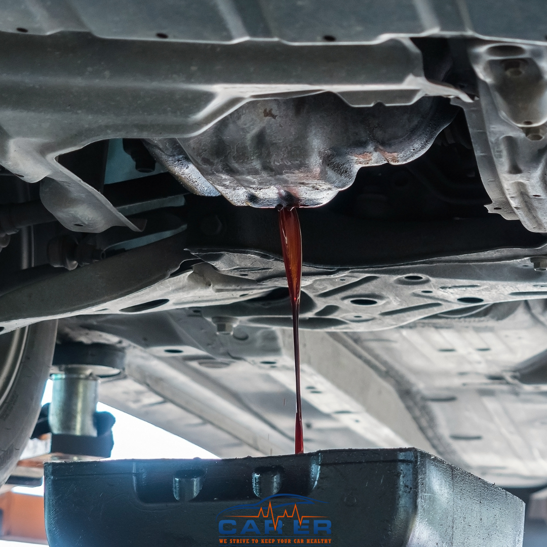 Oil draining from a car's engine into a pan during an oil change at Car ER in Harrisonburg, VA.