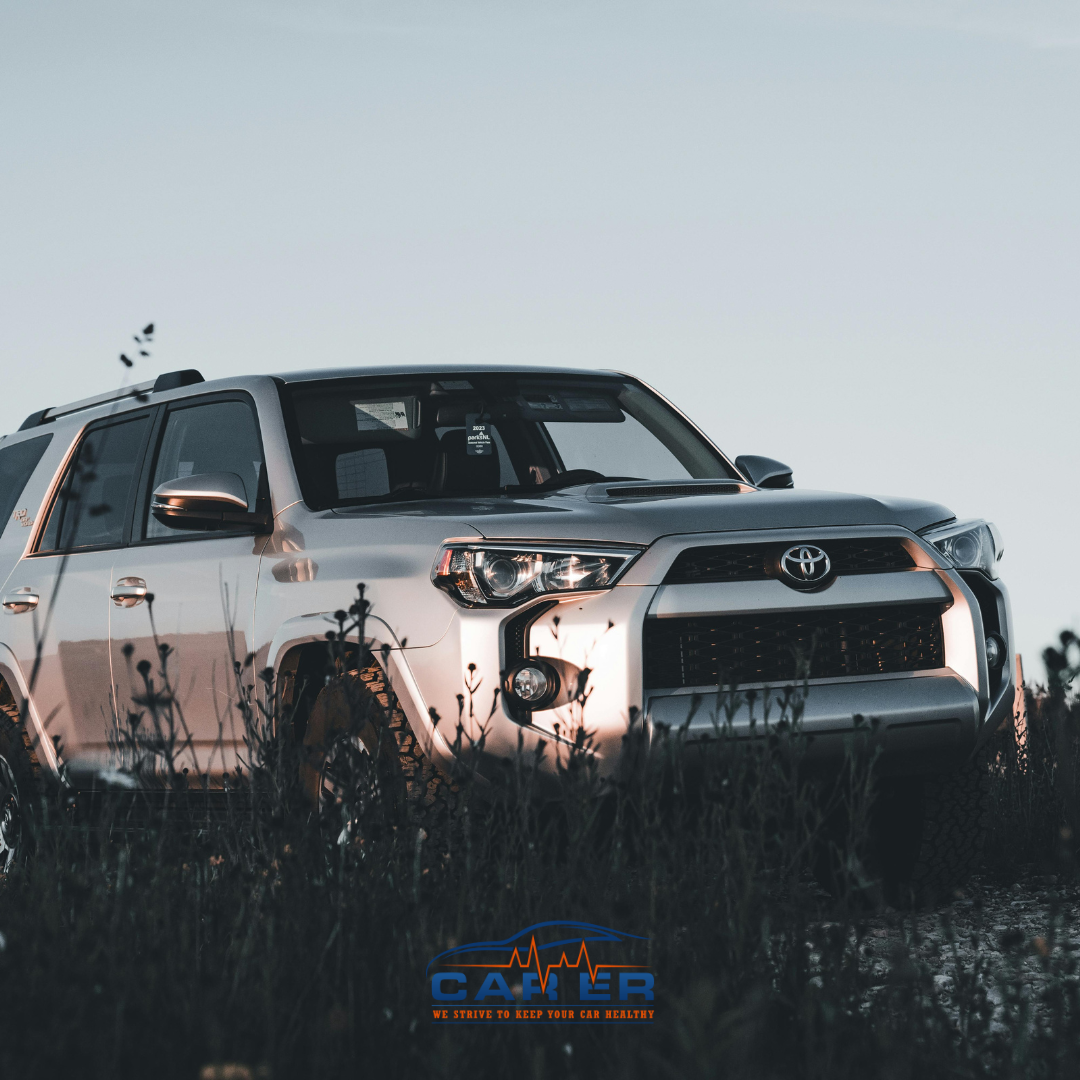 A silver Toyota SUV parked in a grassy field at sunset, showcasing its durability and sleek design. Car ER is the premier Toyota repair shop in Harrisonburg.